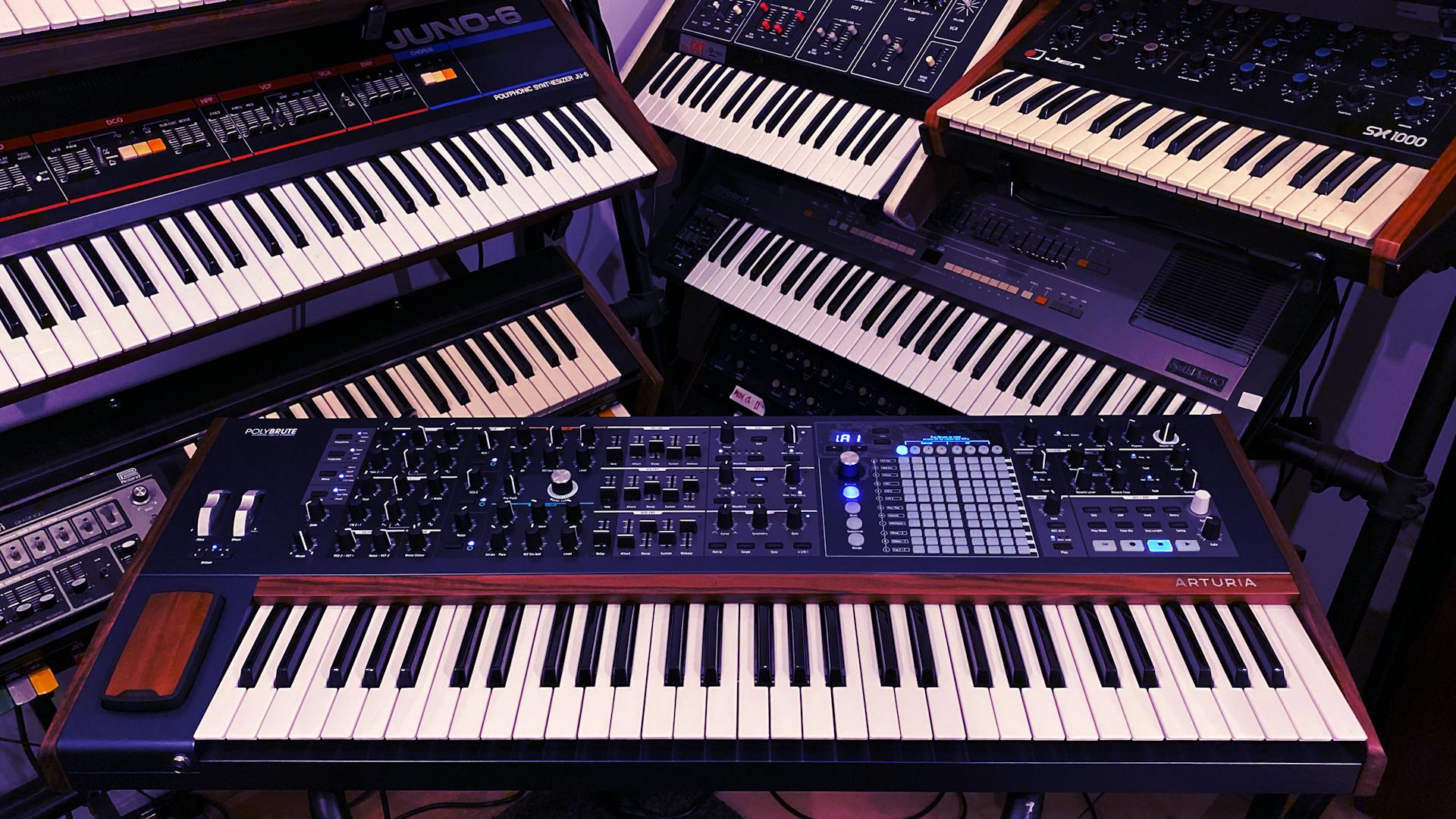 Explore a collection of vintage and modern electronic synthesizers in a studio setting. Perfect for music production enthusiasts.