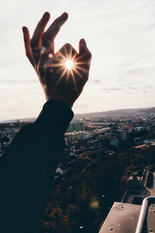 бесплатная Перспективная фотография руки и солнца Стоковое фото