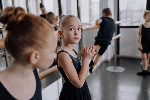 Free Children focusing during a ballet class in a brightly lit studio. Stock Photo