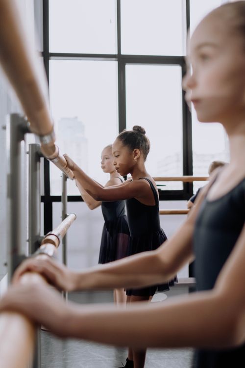 Free Children practicing ballet at the barre in a bright dance studio. Stock Photo