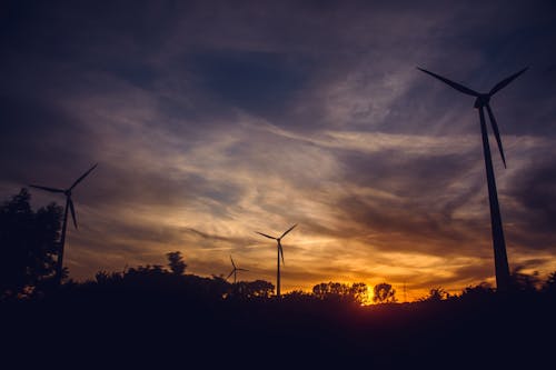 бесплатная Черные ветряные мельницы на закате Стоковое фото