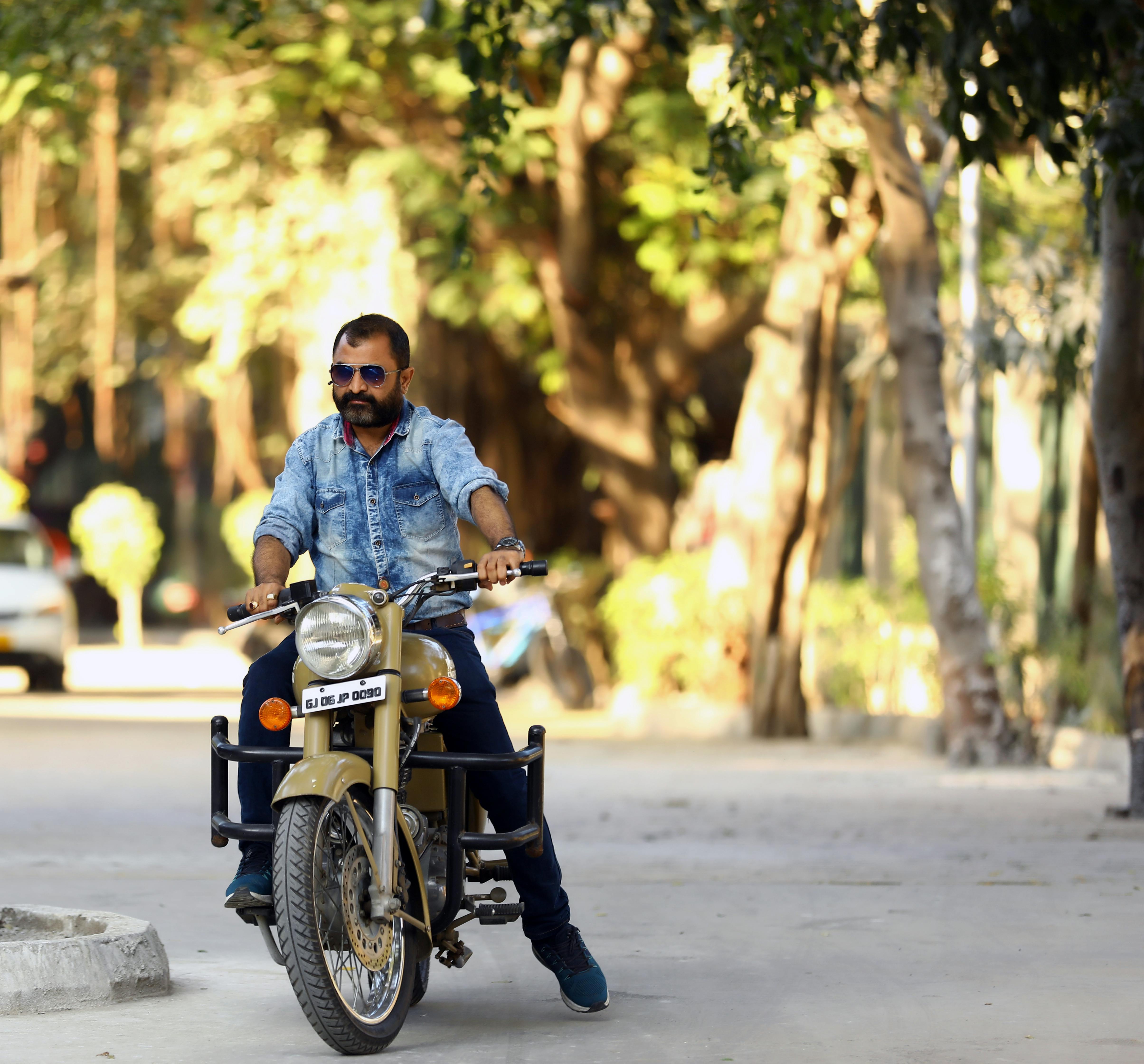 A man sitting on a motorcycle with a microphone · Free Stock Photo