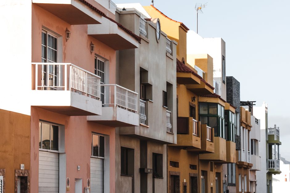 Encantadoras fachadas coloridas de edificios residenciales urbanos en una ciudad española, capturando una arquitectura vibrante.