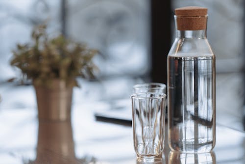 Clear Glass Bottle With Water Beside Drinking Glasses