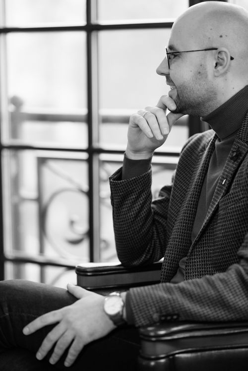 Free Black and white portrait of a contemplative bald man sitting in an easy chair indoors. Stock Photo