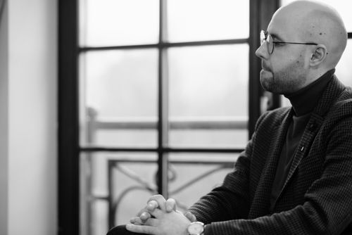 Free A serious man with glasses in a pensive pose indoors, captured in grayscale. Stock Photo