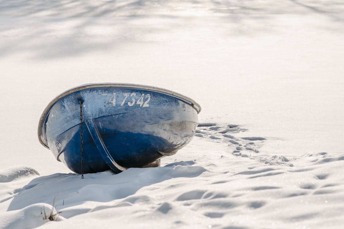 Blue Boat on Snow Covered Ground