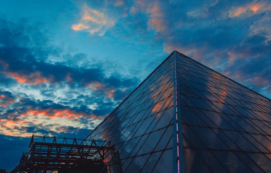 Stunning view of a glass pyramid structure in Viciebsk, Belarus, under a dramatic sunset sky.