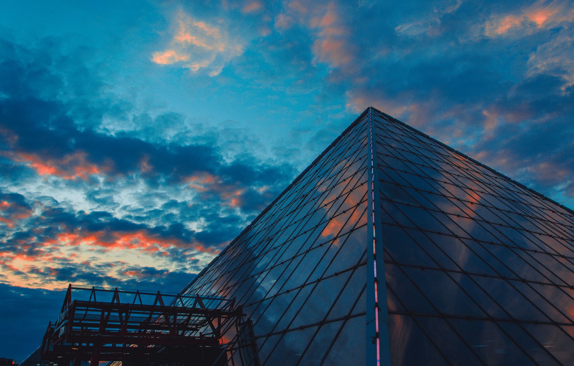 Stunning view of a glass pyramid structure in Viciebsk, Belarus, under a dramatic sunset sky.