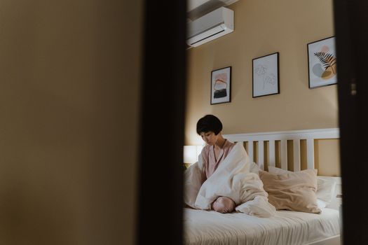 Woman Sitting on White Bed