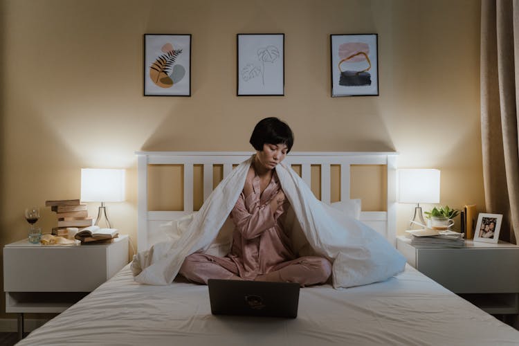 Unhappy Woman Sitting In Bed With Laptop