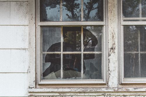 Free Close-up of a broken window pane in an old, weathered house in New York. Stock Photo