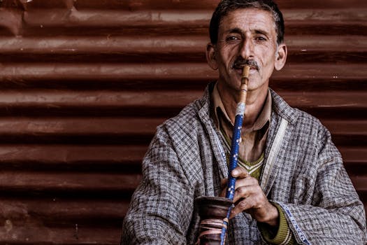 Male Wearing Gray and Black Long-sleeved Shirt Smoking Hookah