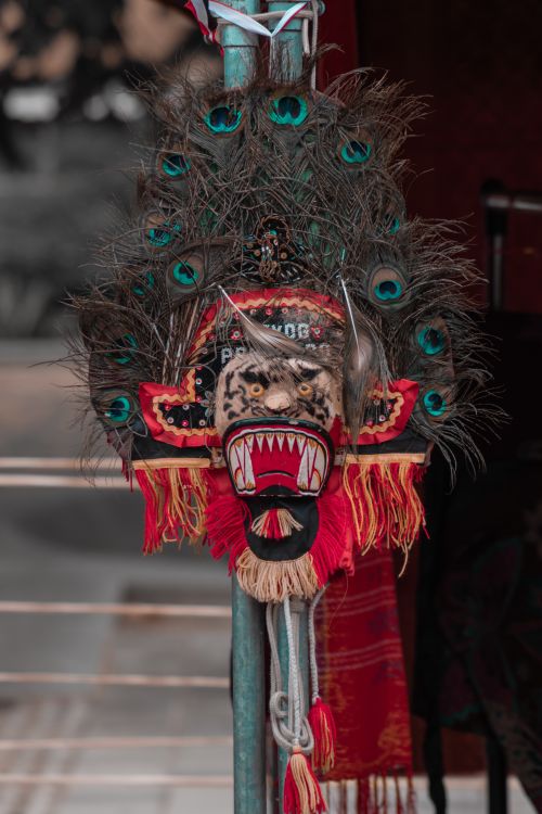 Free Traditional ceremonial mask adorned with striking peacock feathers, showcasing cultural artistry. Stock Photo