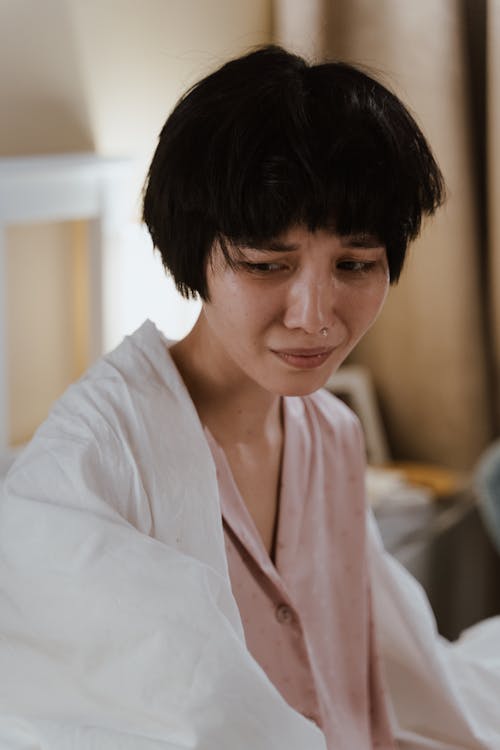 Free Woman Sitting on Bed Crying Stock Photo