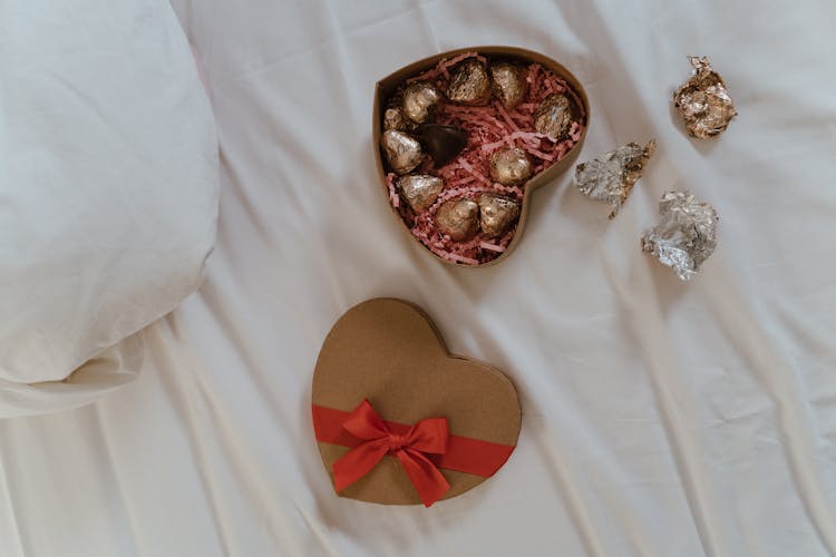 Heart Shaped Box Of Chocolate Candies On White Linen