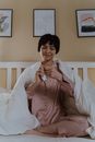 Woman in Pink Button Up Shirt Sitting on Bed