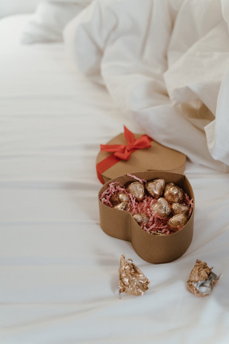 Heart Shaped Box Of Chocolates On Bed