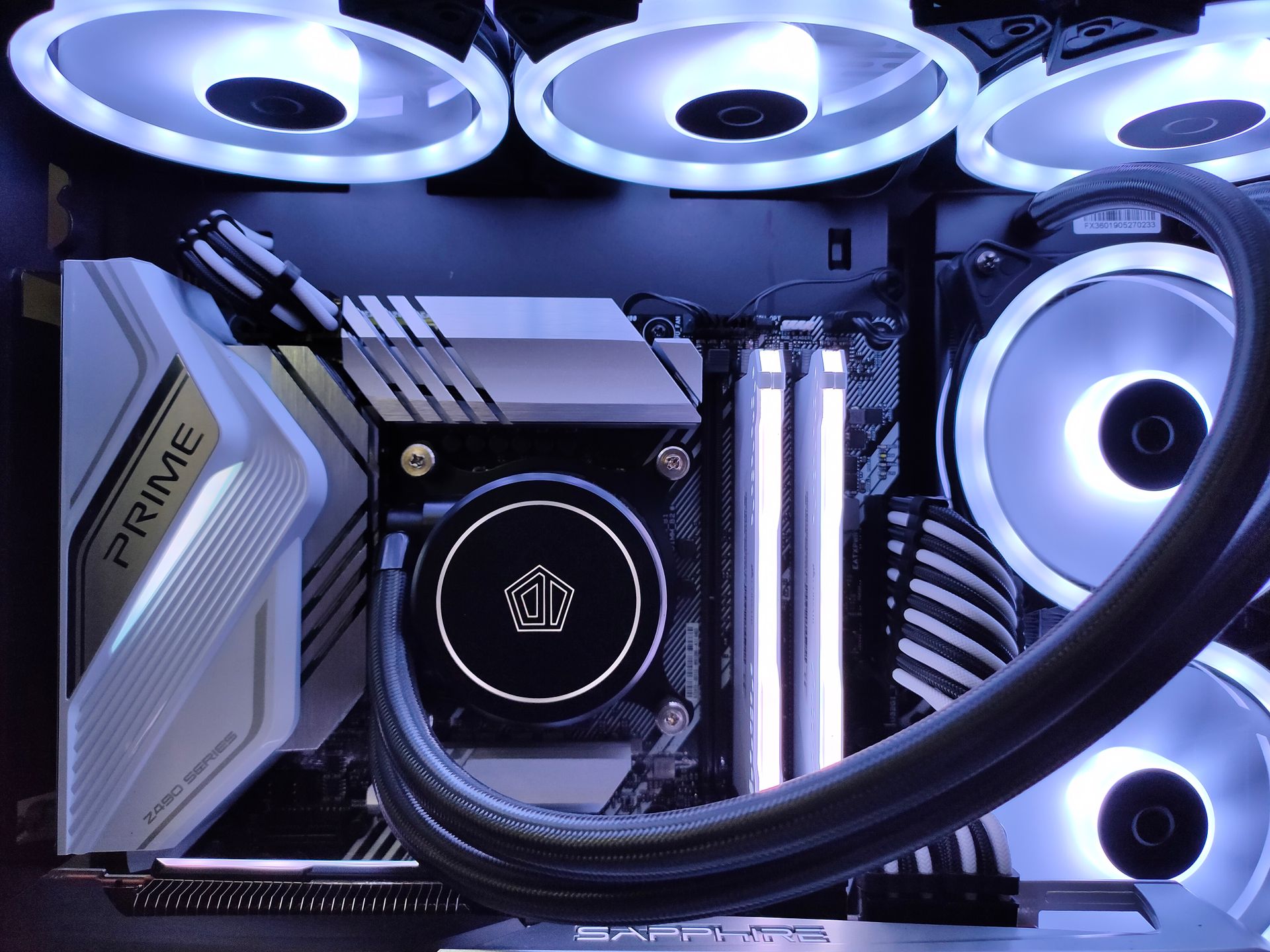 Detailed view of a computer setup with LED fans, motherboard, and graphics card in a gaming rig.