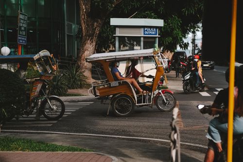 Free Tricycle carrying passengers in Dumaguete, Philippines, showcasing local transport. Stock Photo