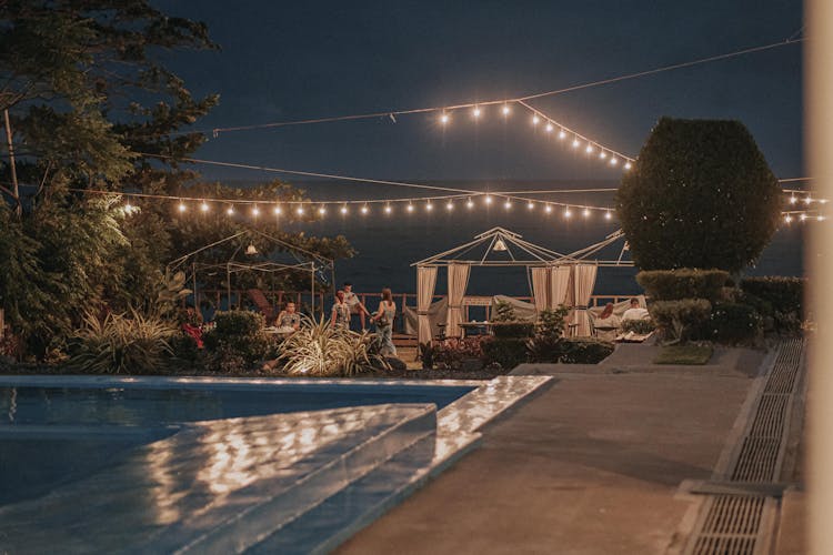 People Meeting By Swimming Pool At Night