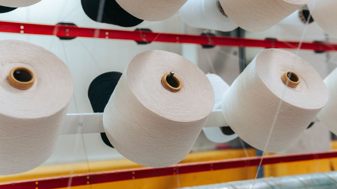 Industrial yarn cones in white and black on a textile creel, prepared for yarn selection