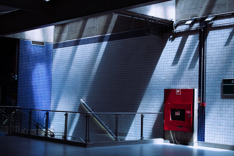 A Red Metal Cabinet On A Tiled Wall