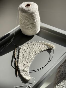 A detailed view of crochet work in progress using white yarn and a crochet hook.