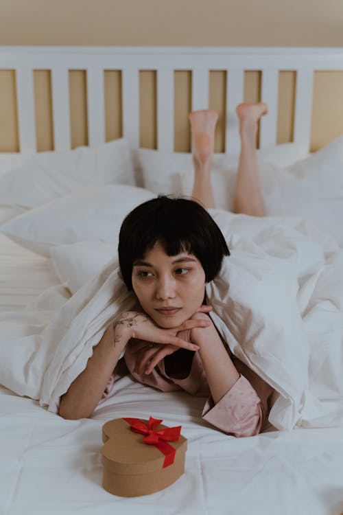 Woman Lying on Bed with Gift