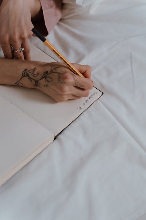 Foto profissional grátis de caderno, caneta, escrevendo