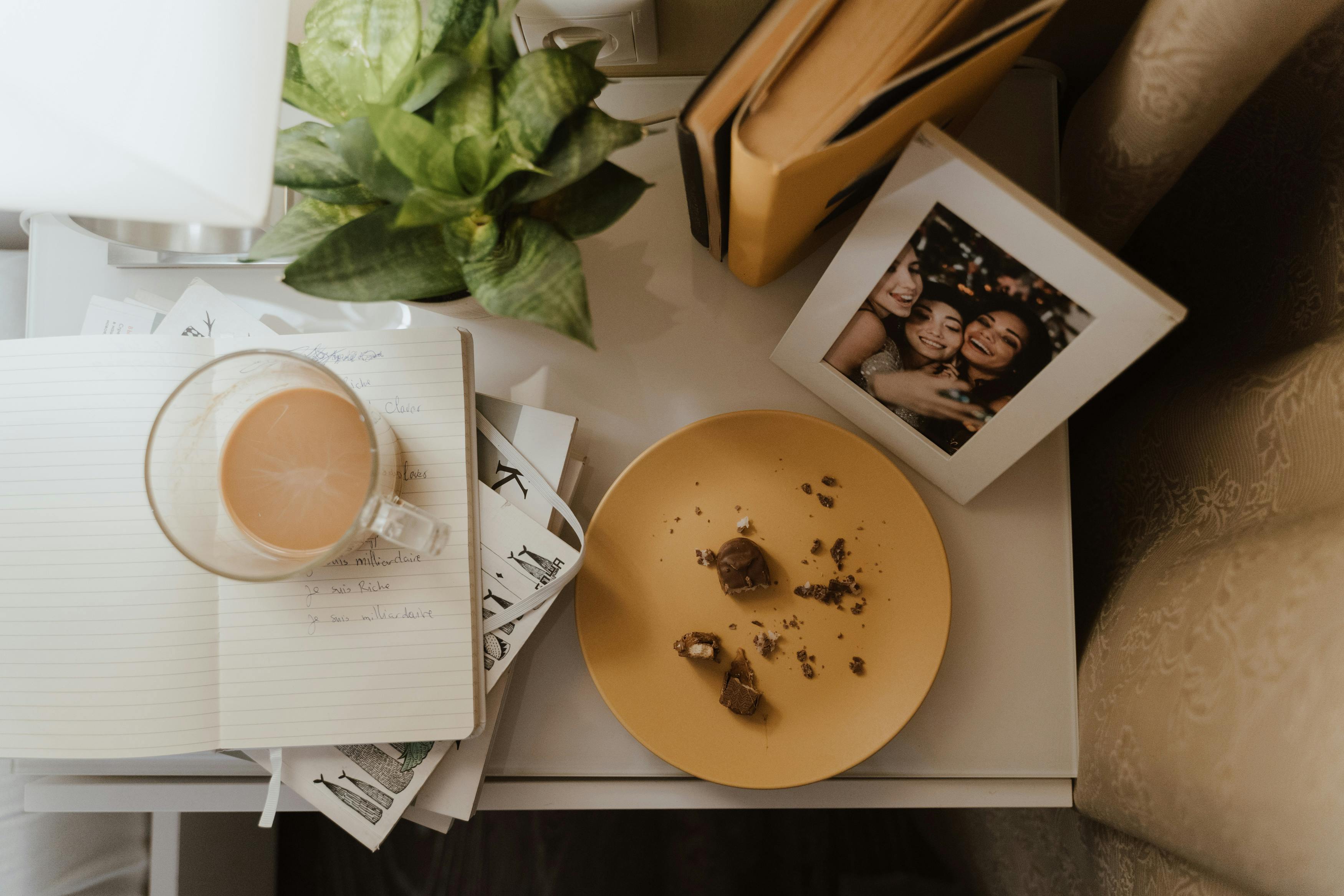 Free Overhead view of a cozy reading corner with coffee, books, and cherished memories. Stock Photo