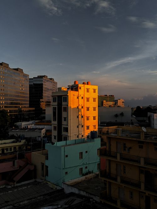 Free From above of aged and new modern residential multistory houses under cloudy sky in sunset time in city Stock Photo