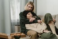 Woman in Green Long Sleeve Shirt Sitting on Brown Sofa Chair