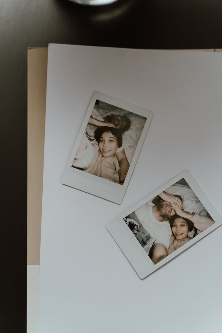 Polaroid Pictures Of A Couple Lying On White Background 