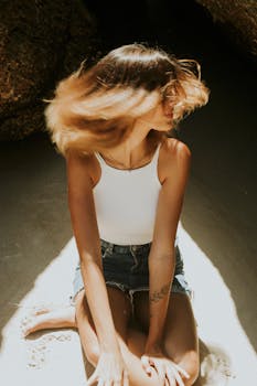 A vibrant sunlit portrait of a woman sitting on the sand at a beach in Brazil.