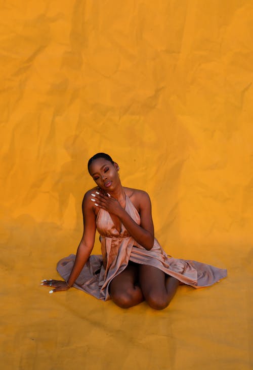African American woman in dress on yellow background