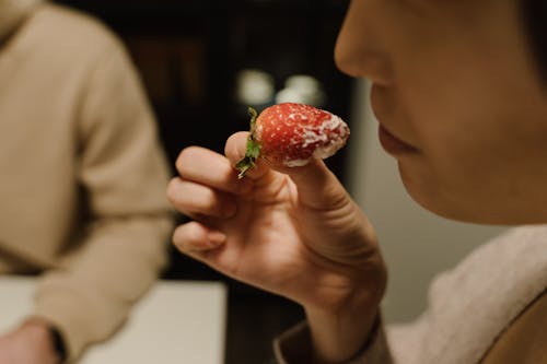 Close-Up Shot of a Person Eating a Strawberry