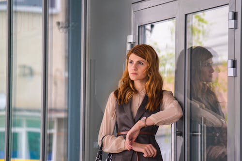 Free Woman Standing Near Clear Glass Gray Framed Door Panel Stock Photo