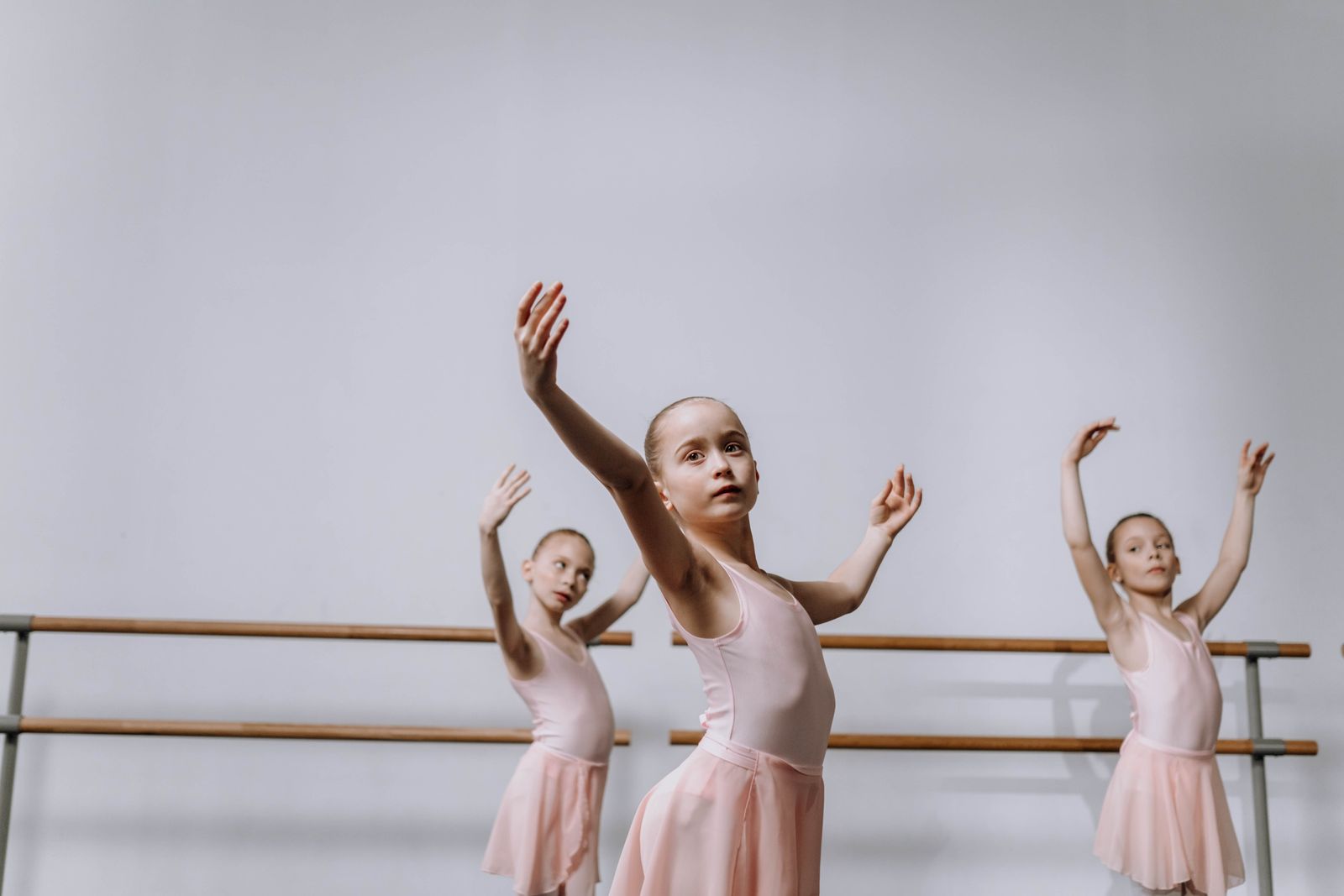Group of children in a colorful dance class following an instructor's moves