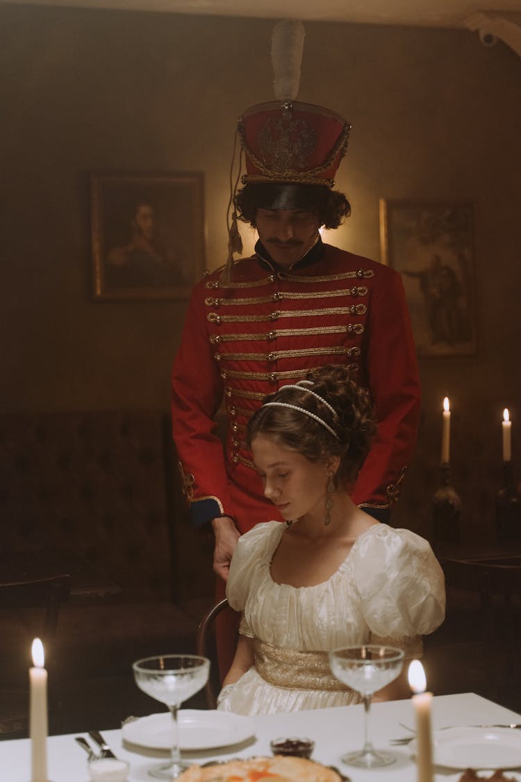 Man Standing Near A Woman Sitting At Table