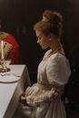 Woman in White Floral Lace Wedding Dress Sitting Beside Table