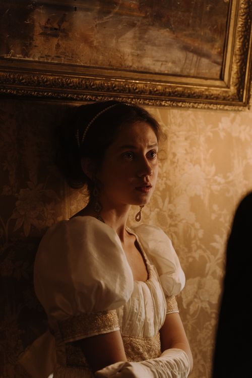 Free Portrait of a woman in elegant 19th-century attire, captured indoors with warm lighting. Stock Photo