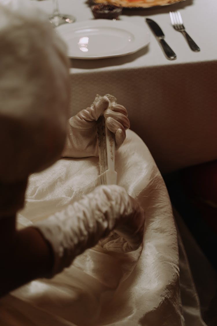 Person Wearing White Silk Gloves Holding A Hand Fan 