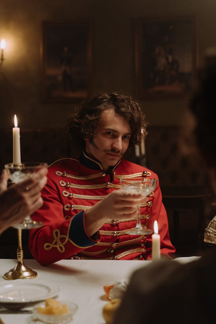 Man Wearing Scarlet Tunic Holding A Drink