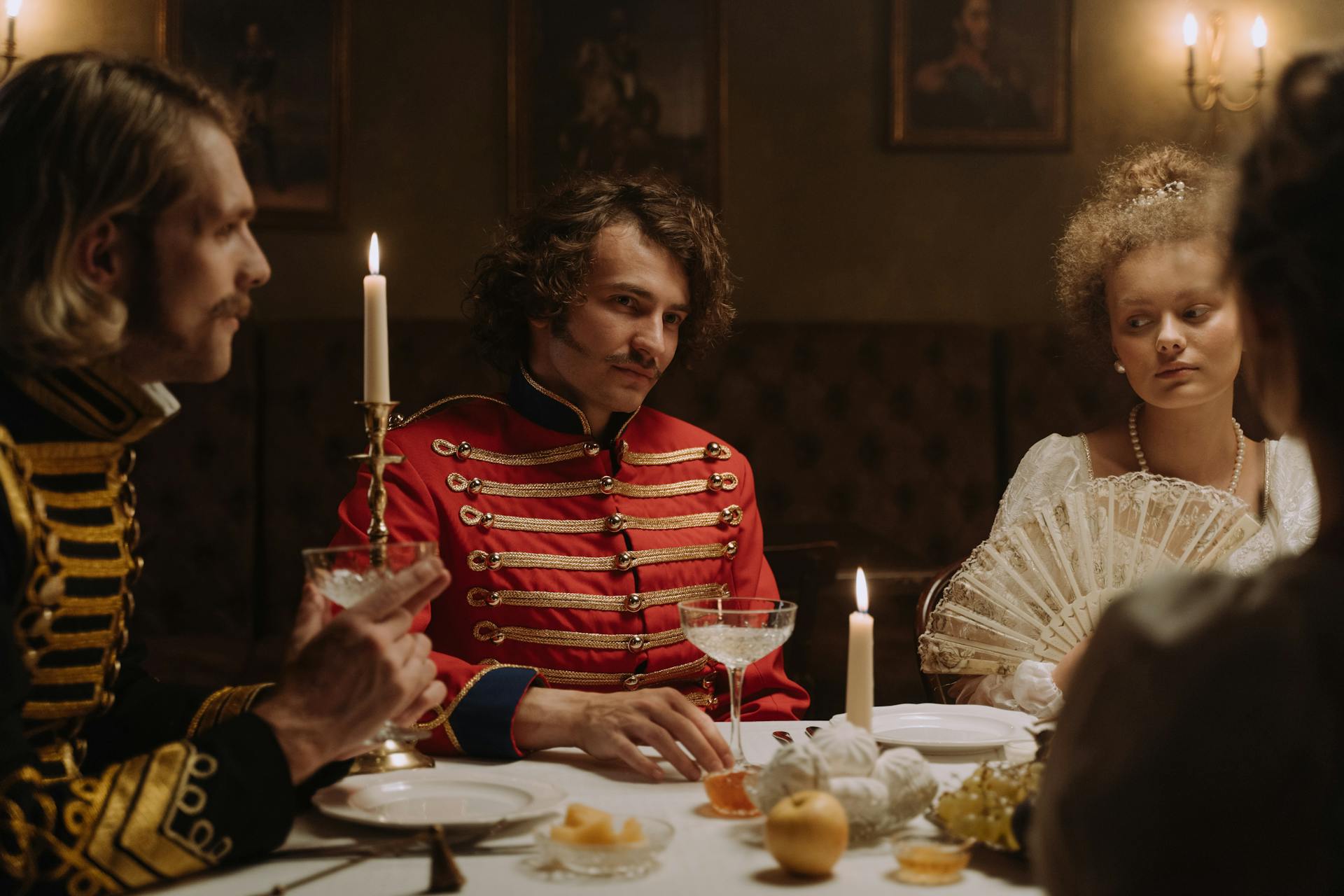 Group of People Dressed as Aristocracy Sitting at the Table and Dining