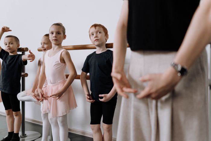 Children learning dance with their instructor in class