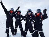 四个穿着冬装、戴着头盔的成年人正在雪地里享受冒险