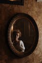 一位穿着古装的女子映照在复古镜子中，营造出一种贵族氛围