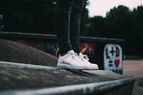 Free Human Standing on the Ground and Wearing White Nike Sneakers Stock Photo