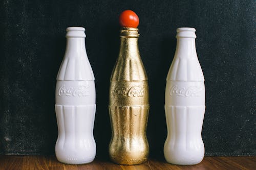 三个白色和黄铜可口可乐瓶